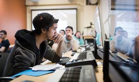 students in a music class sitting at keyboards and looking at computers